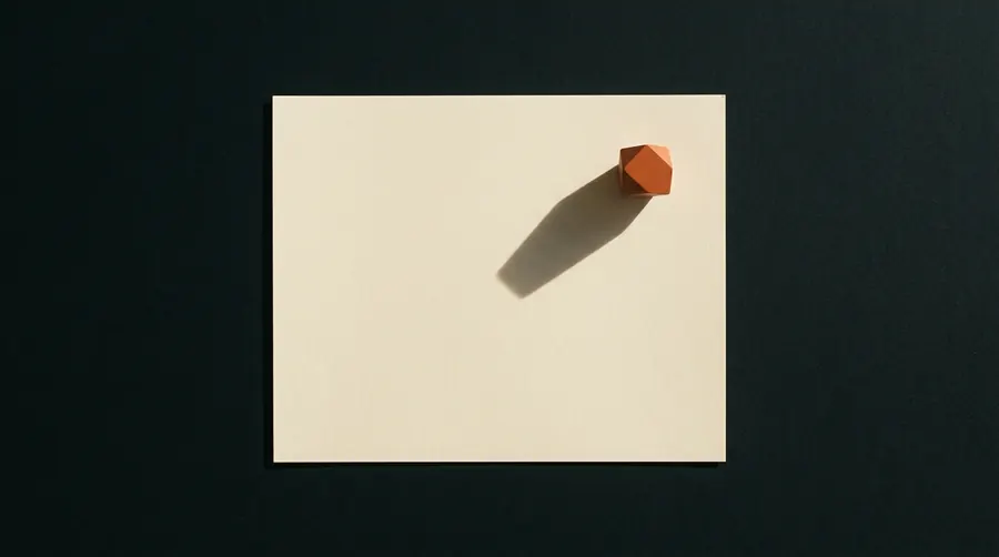 A single sheet of paper on a dark surface, lit from the side